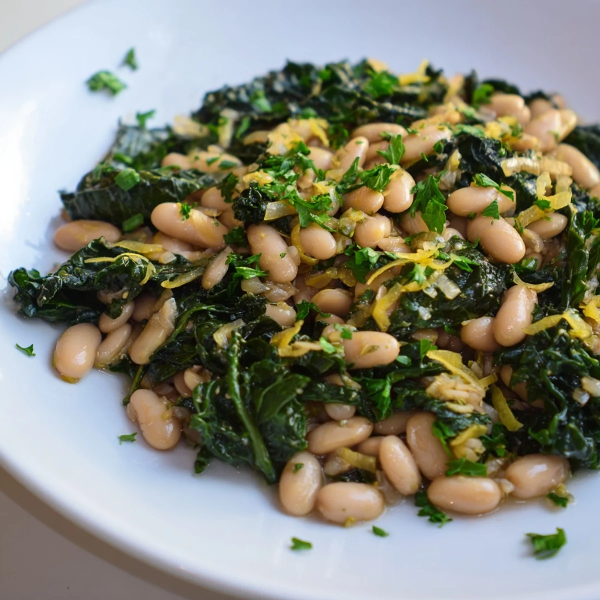 Close-up of hearty Garlicky Beans with Winter Greens, a flavorful, healthy meal with bright lemon zest.