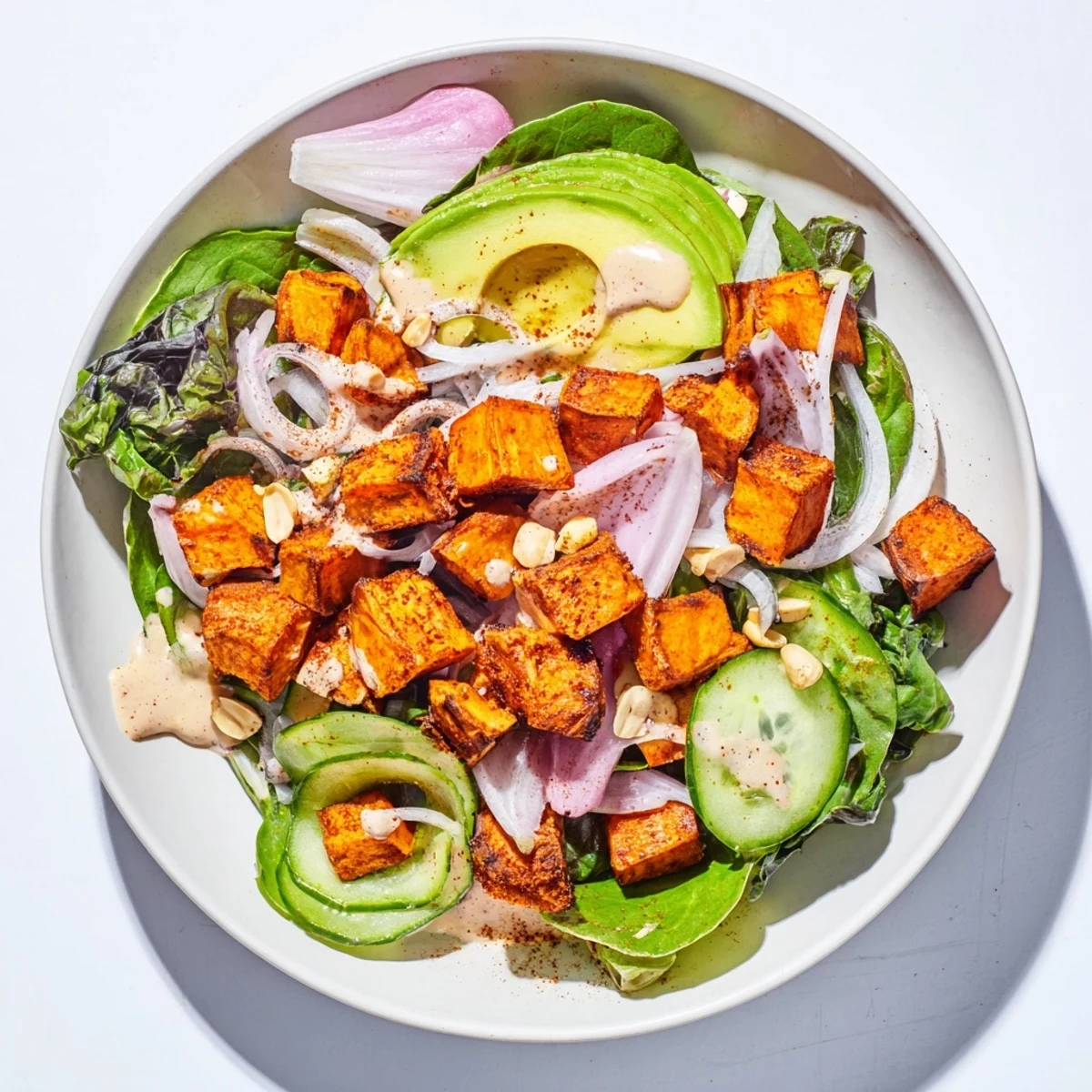 A colorful Spiced Peanut Sweet Potato & Radicchio Salad Bowl, drizzled with zesty peanut dressing just before serving.