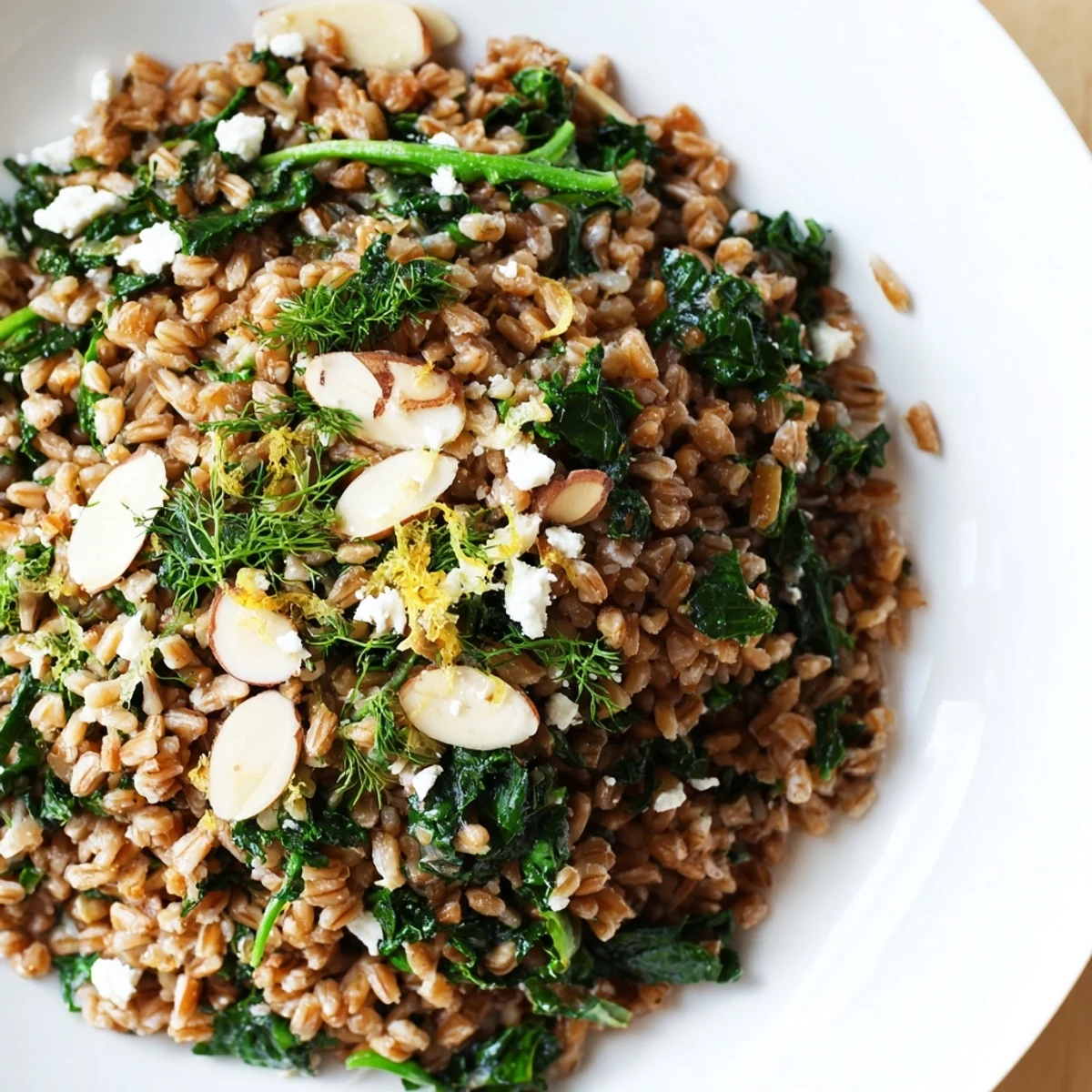 Golden farro pilaf with toasted almonds, featuring vibrant greens and a lemon zing, ready to eat.