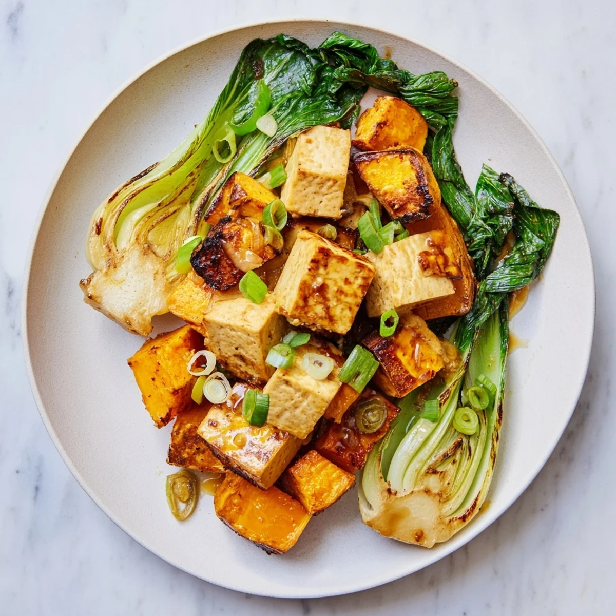 Golden, glistening miso-glazed tofu and winter squash alongside steamed bok choy, a vibrant meal.