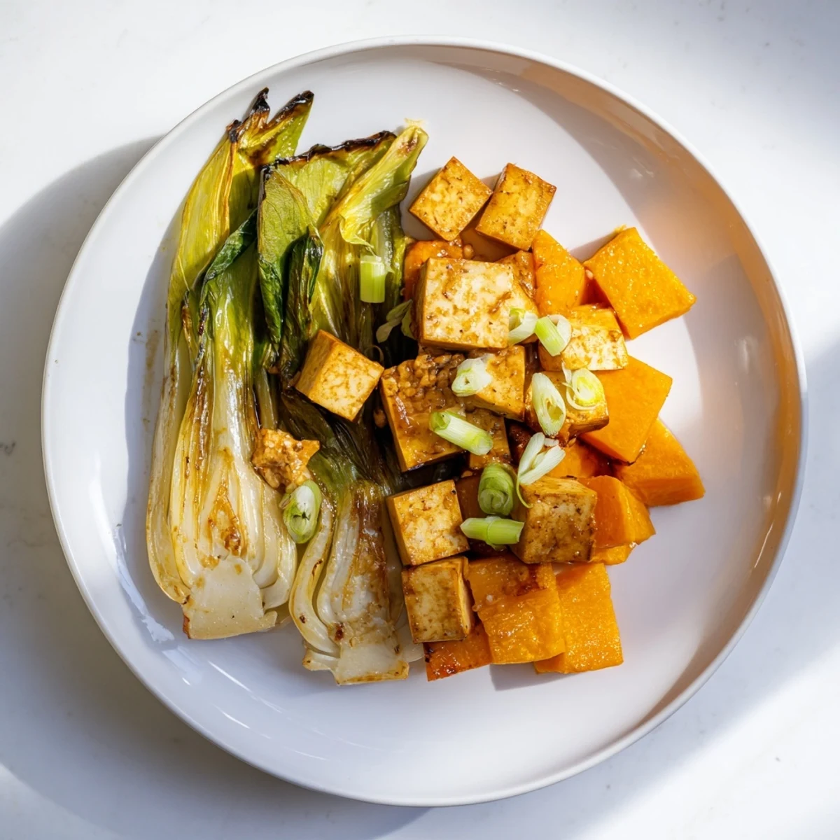 Savory miso glaze coats caramelized miso-glazed tofu and squash, a flavorful vegan main dish.