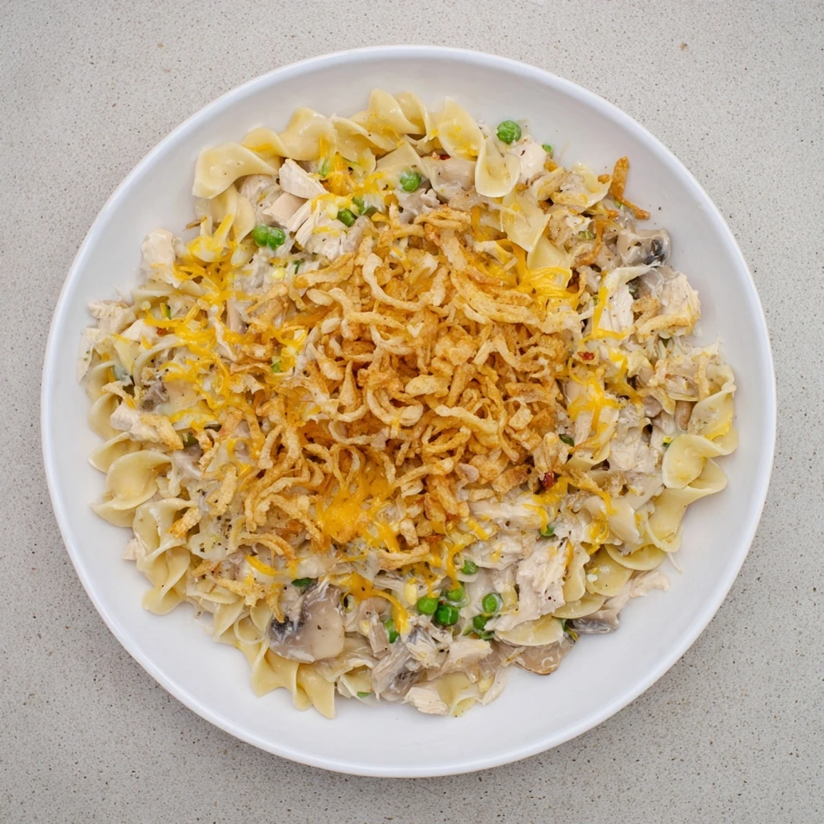 A close-up view of a steaming plate of creamy tuna noodle casserole, ready to serve.