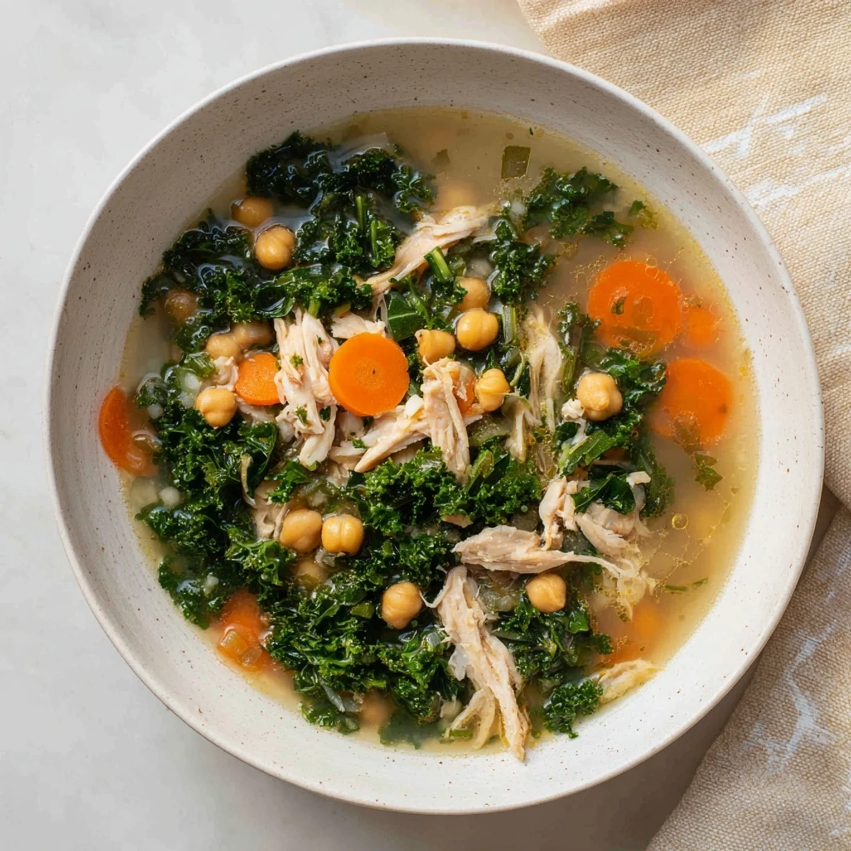 Chicken Kale Soup with Crispy Chickpeas, a warm bowl of hearty soup with golden, crispy chickpeas.