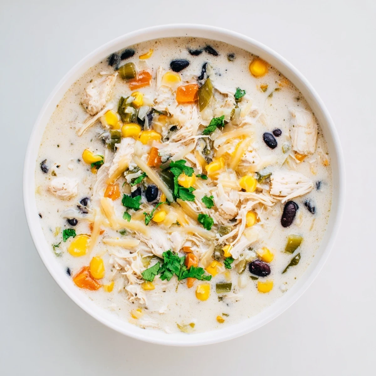 Chicken Poblano Soup, a creamy, golden soup, garnished with fresh cilantro, ready to serve and enjoy.