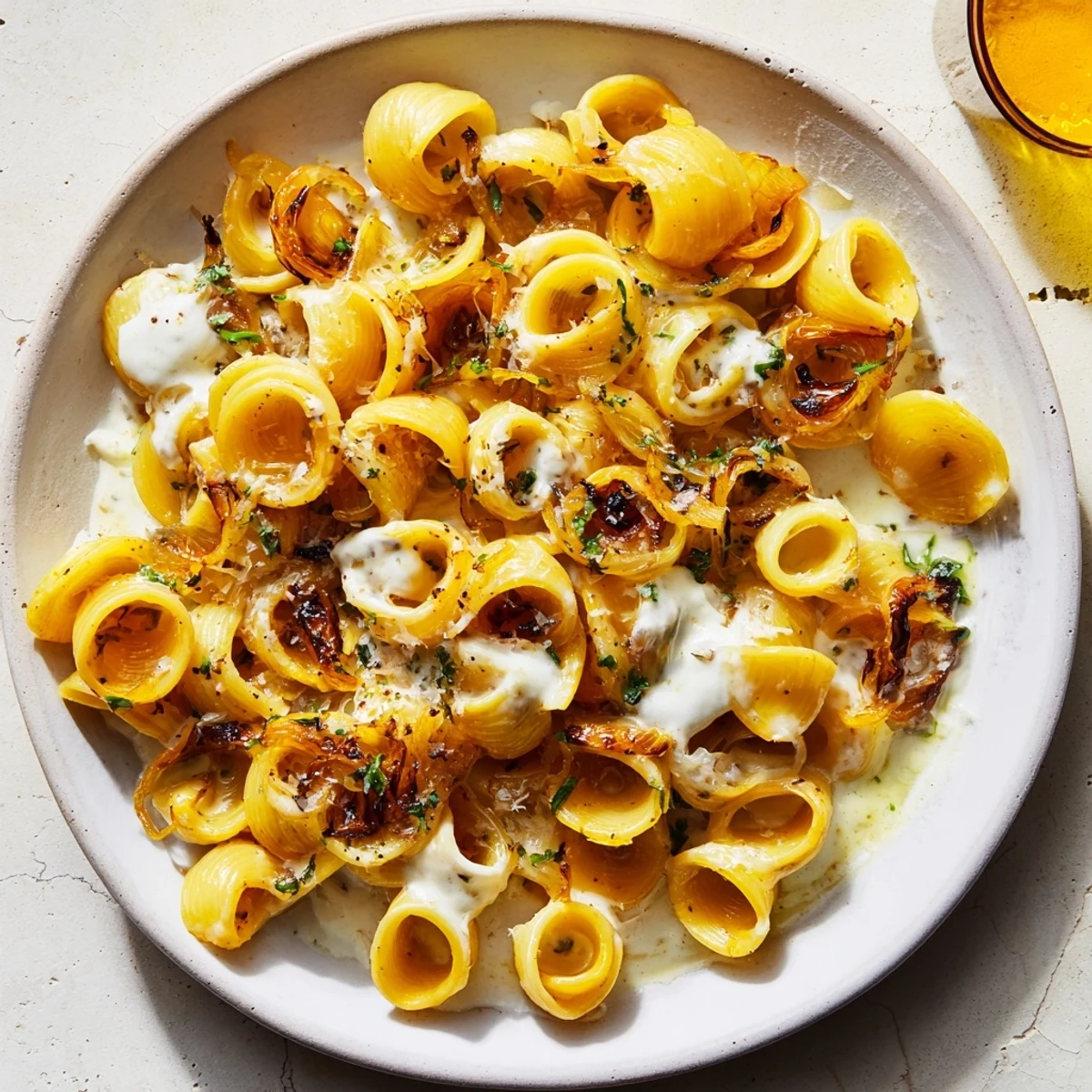 A warm bowl of Creamy French Onion Ditalini, topped with melted cheese and fresh herbs, ready to serve.