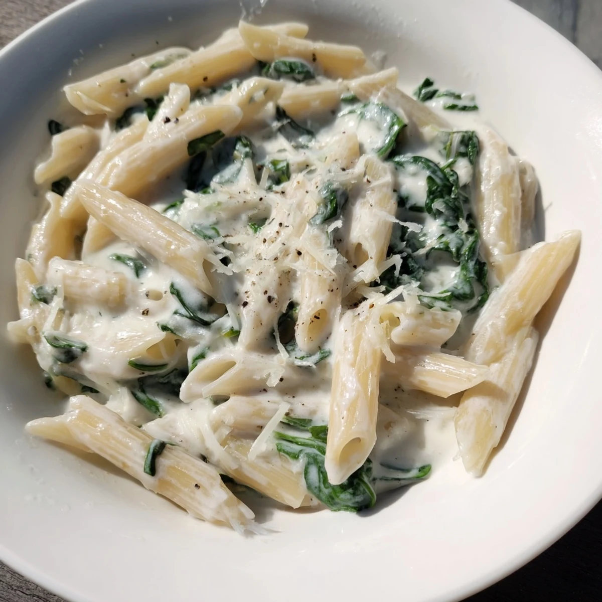 A visually appealing photo of the creamy spinach pasta, ready to enjoy with parmesan.