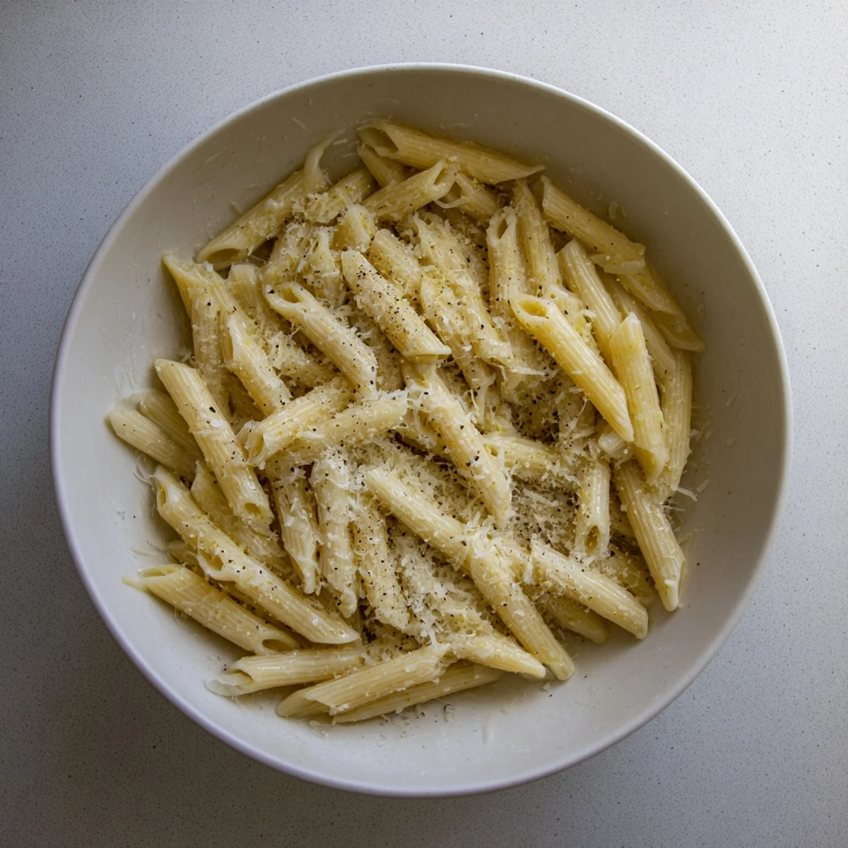 Freshly prepared microwave bowl pasta with elbow macaroni, mixed with pesto and grated cheese, ready to eat in under 12 minutes.