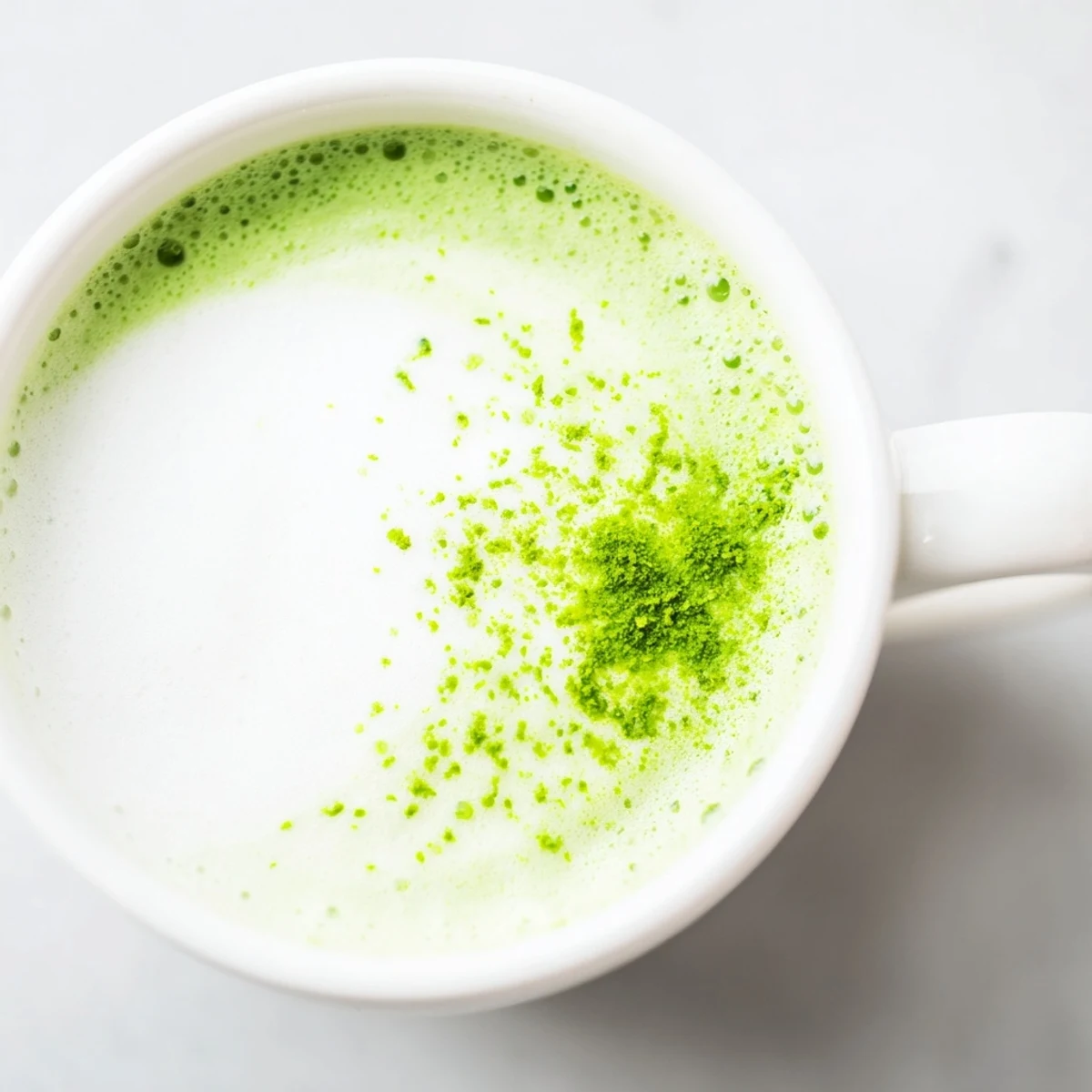 A freshly whisked matcha latte with creamy steamed milk and a golden drizzle of honey on a cozy morning table.  