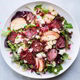 The festive Hot Girl Christmas Salad features a vibrant mix of greens, pomegranate, and crumbled cheese.