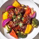 Golden brown Spicy Honey-Garlic Chicken thighs nestled among colorful bell peppers and onions, ready to enjoy.