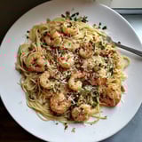 Golden One-Skillet Lemon Garlic Shrimp Angel Hair Pasta, ready to serve with Parmesan cheese and parsley.