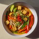 A creamy, fragrant serving of Malaysian Laksa Curry featuring noodles, tofu, and a rich coconut broth.