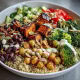 The finished Meal Prep Week-Long Power Bowl with vibrant fresh veggies, black beans, and a generous drizzle of creamy tahini dressing.
