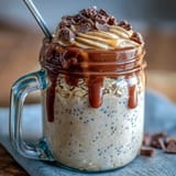Vanilla Bean Frappuccino Overnight Oats Jar with creamy vanilla and coffee layers, topped with whipped cream and chocolate chips for a breakfast treat.