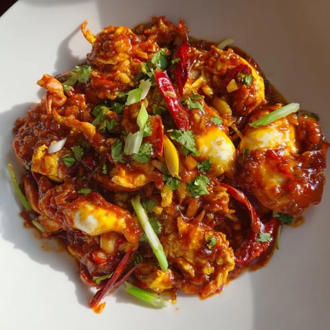 Steaming Singaporean chili crab, covered in a vibrant red sauce, ready to be devoured with fluffy buns.