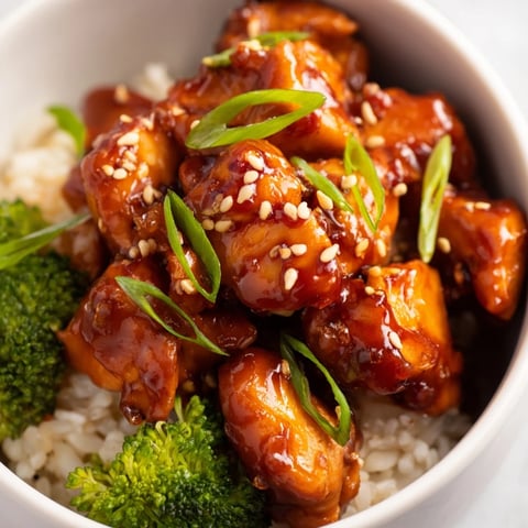 A close-up of Sweet Chili Chicken Bowl with glazed chicken, fluffy rice, and vibrant green steamed broccoli.