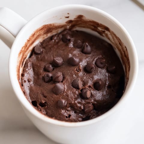 Close-up of a tender chocolate microwaved mug cake, perfectly cooked with a soft, moist texture.