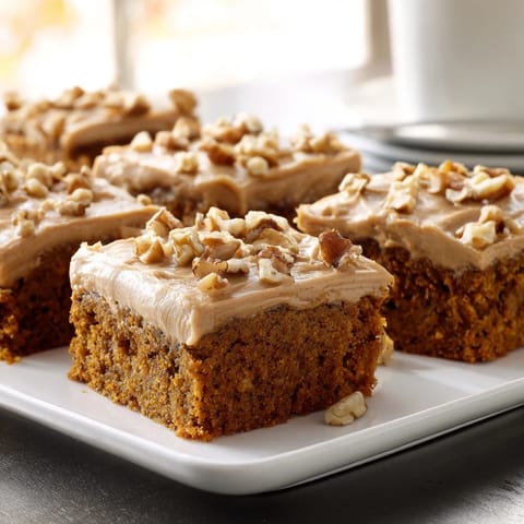 Close-up of a perfectly frosted pumpkin bars tray, showcasing a creamy topping, ideal dessert.