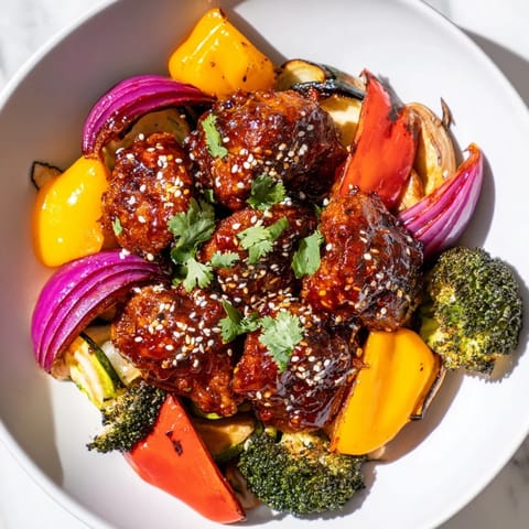 Golden brown Spicy Honey-Garlic Chicken thighs nestled among colorful bell peppers and onions, ready to enjoy.