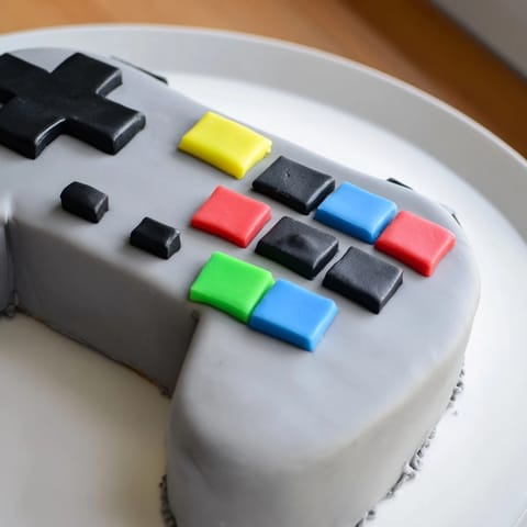 This homemade video game controller cake presents a colorful, pixelated design—a perfect dessert for gamers everywhere.