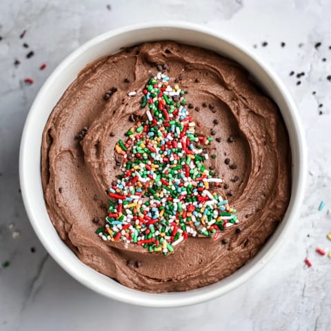A scoop of rich, dark Festive Tree Brownie Dip, shimmering with holiday sprinkles, perfect for dipping and sharing around.