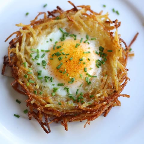 Golden-brown, savory Crispy Hashbrown Egg Nests overflowing with cheese and perfectly cooked eggs.