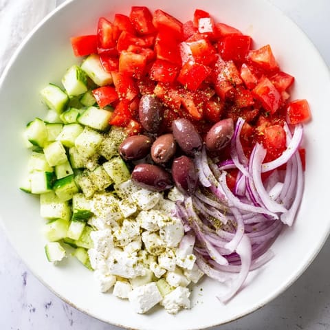A close-up of a refreshing Mediterranean salad, showcasing vibrant vegetables and olives.