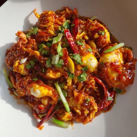 Steaming Singaporean chili crab, covered in a vibrant red sauce, ready to be devoured with fluffy buns.