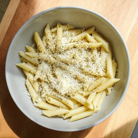 Steaming microwave bowl pasta with fusilli and olive oil, served in a white ceramic bowl for a simple, single-serve Italian-American meal.