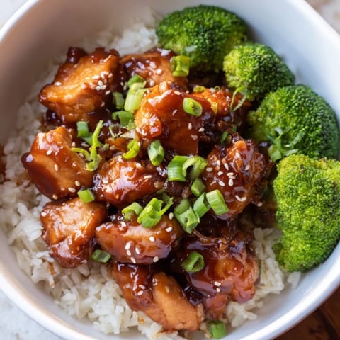 Sweet Chili Chicken Bowl served in a rustic ceramic bowl, topped with sesame seeds and fresh green onions.