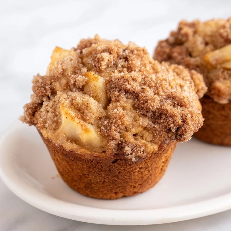 Image of fluffy Cinnamon Apple Muffins, studded with apple chunks, perfect for a fall treat.