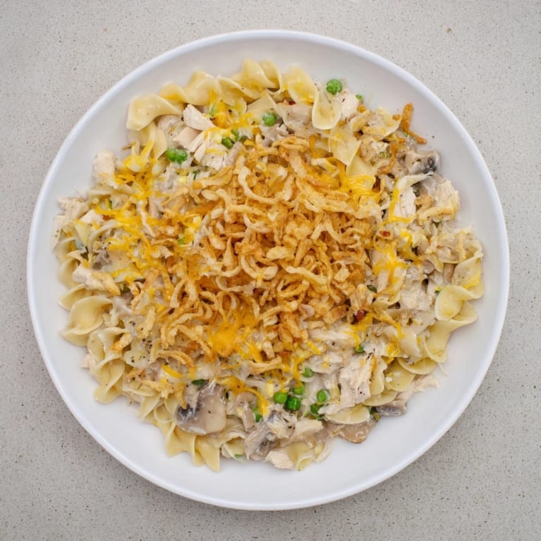 A close-up view of a steaming plate of creamy tuna noodle casserole, ready to serve.