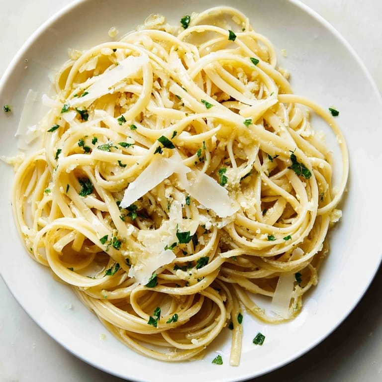 Close-up of creamy Garlic Butter Linguine, perfectly coated, with Parmesan cheese sprinkled on top.