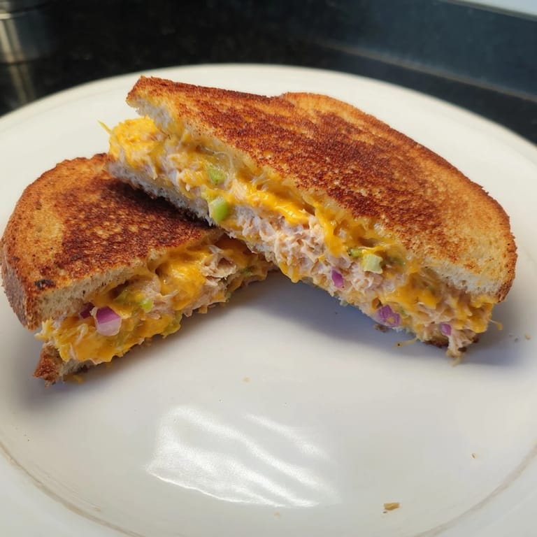 Sizzling Spicy Tuna Melt on sourdough with melted cheddar and a touch of sriracha.  