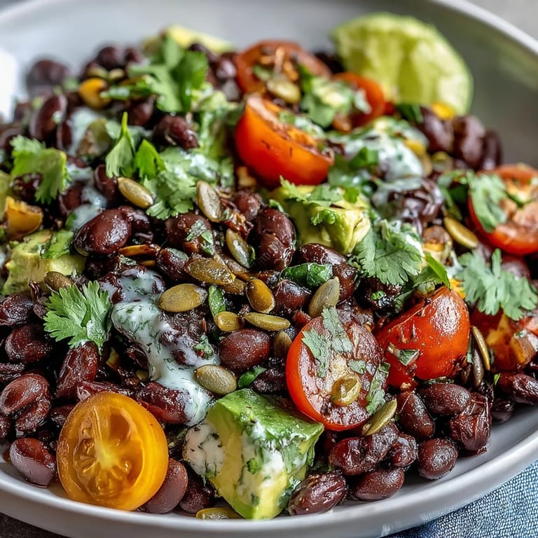 A fresh Black Bean and Veggie Bowl garnished with cilantro and lime, served in a white ceramic bowl for a vibrant meal.