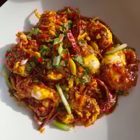 Steaming Singaporean chili crab, covered in a vibrant red sauce, ready to be devoured with fluffy buns.