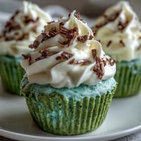 Festive green velvet cupcakes with cocoa flavor, topped with creamy cream cheese frosting for St. Patrick's Day celebrations.